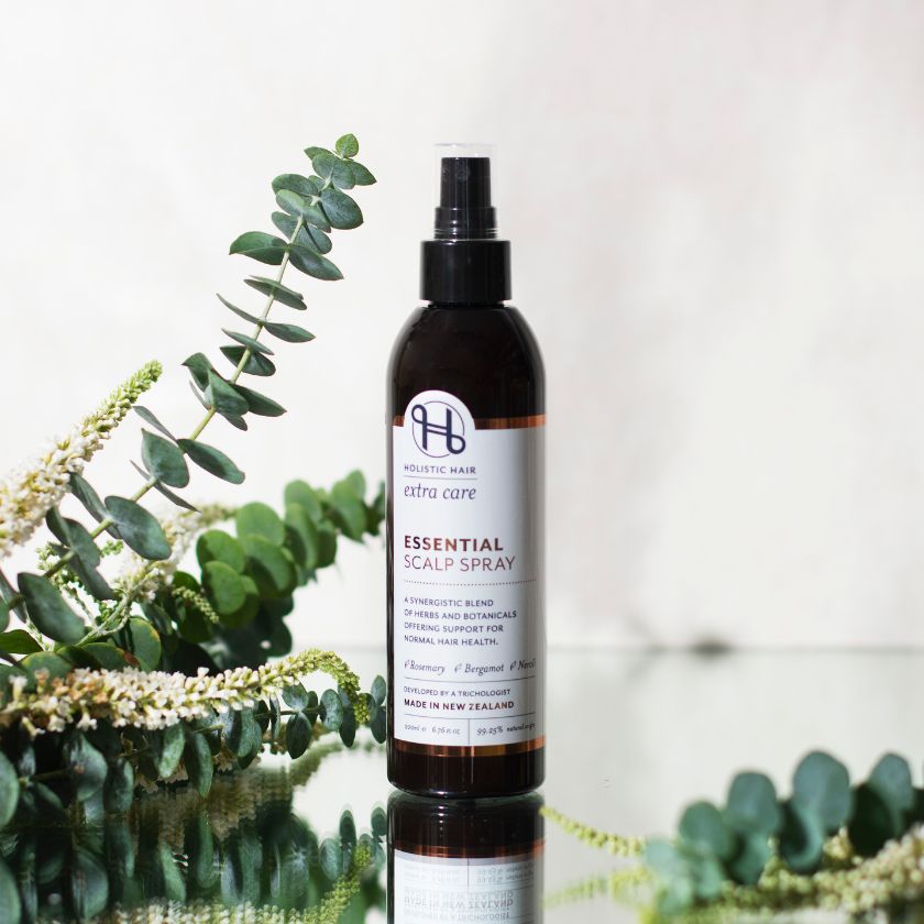 Essential Scalp Spray on a botanical background.