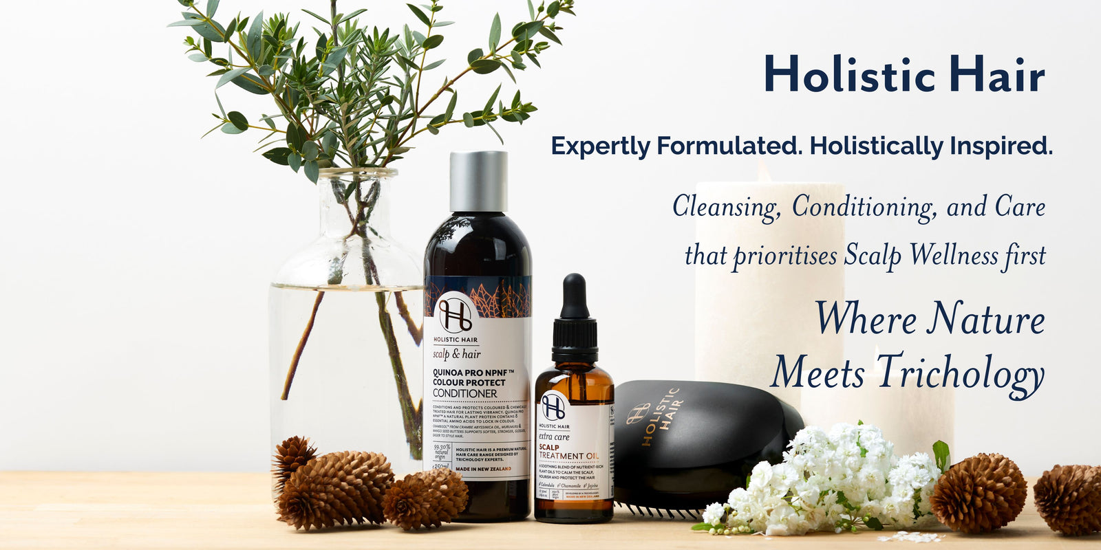 Holistic Hair product line with bottles, a candle, and decorative elements on a light background.